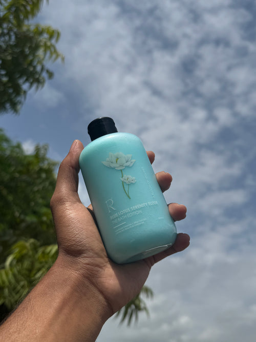 Blue Lotus Serenity Elixir blue bottle held outdoors